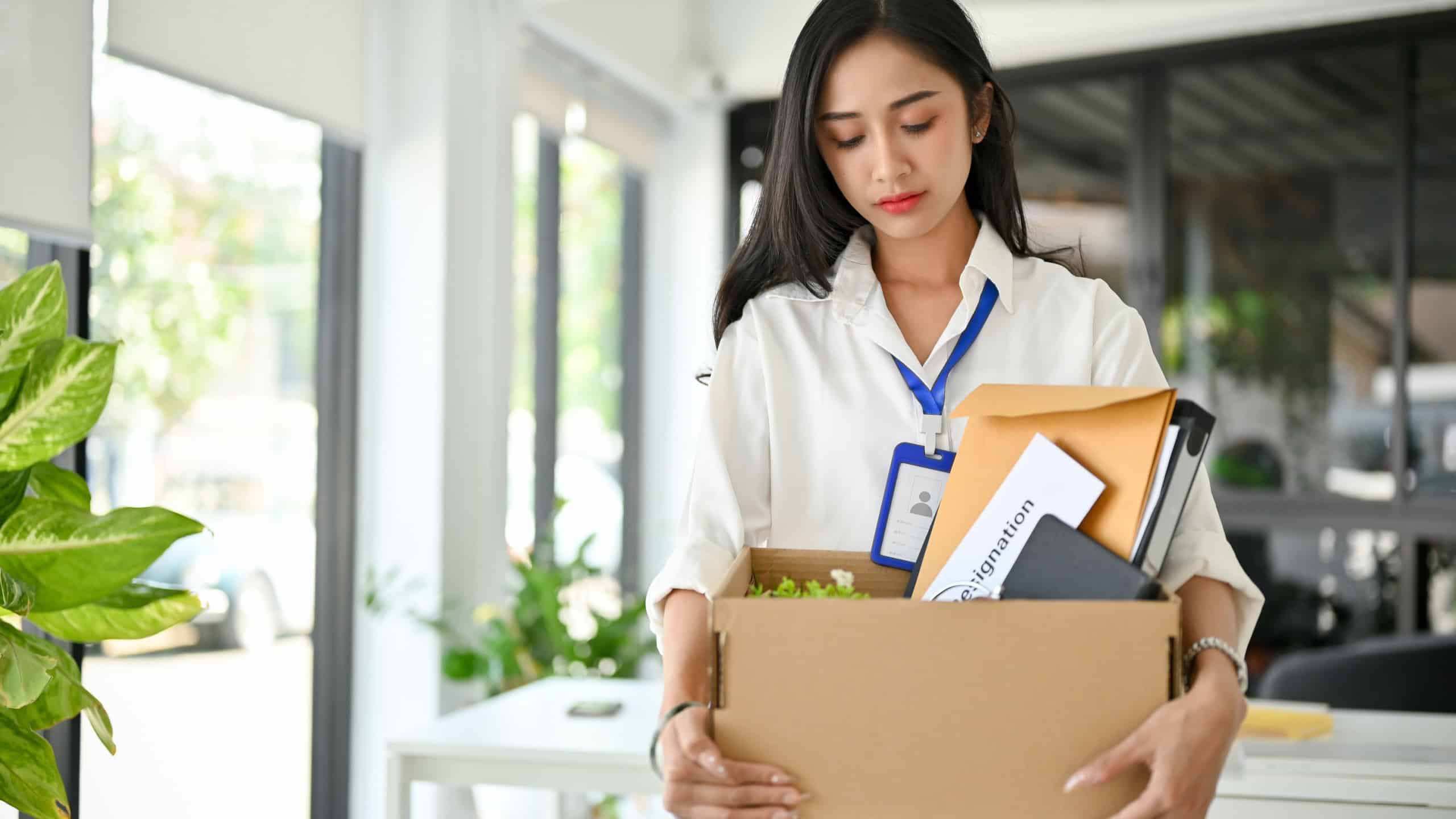 Sad and frustrated millennial Asian female office worker carrying her belonging, quitting a job. unemployment, resign, career failure