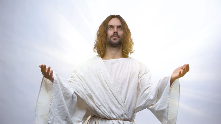 Jesus raising hands to heaven on illuminated background, Resurrection holiday
