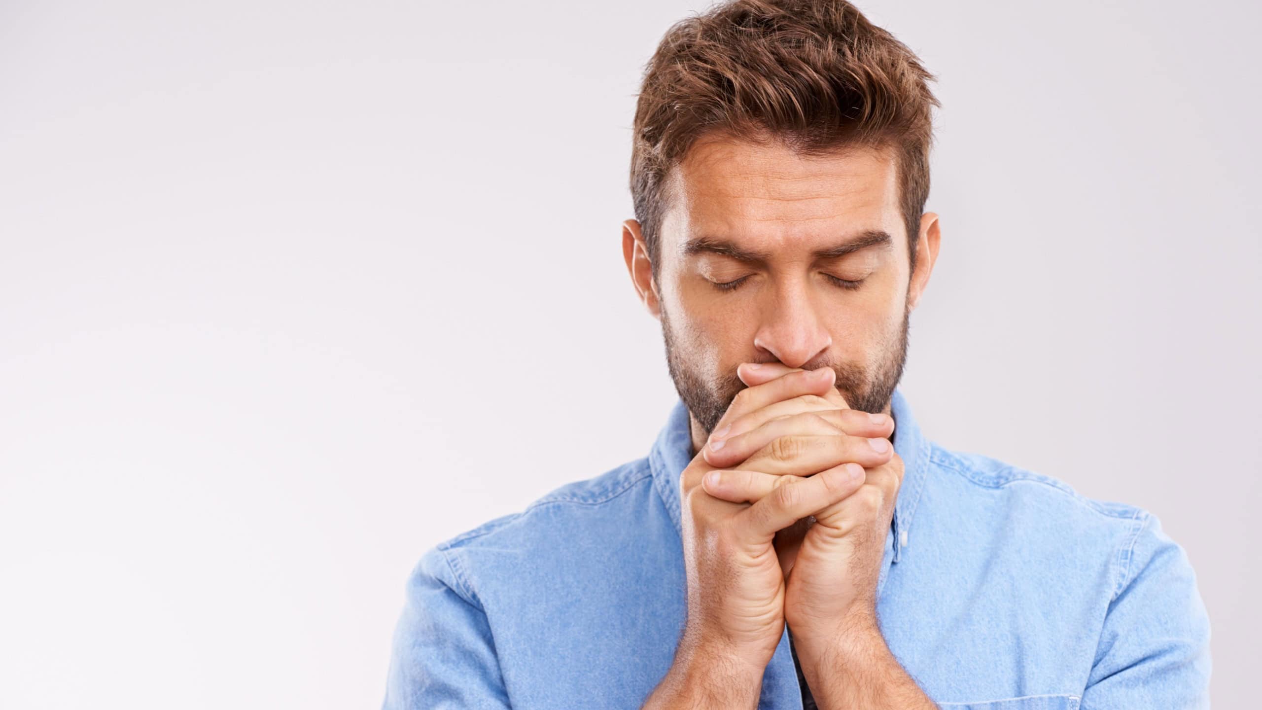 Man, praying and worship with hope and faith in God, seek help and advice for guidance on white background. Spiritual, religion and gratitude with thanks, prayer and forgiveness with belief in studio