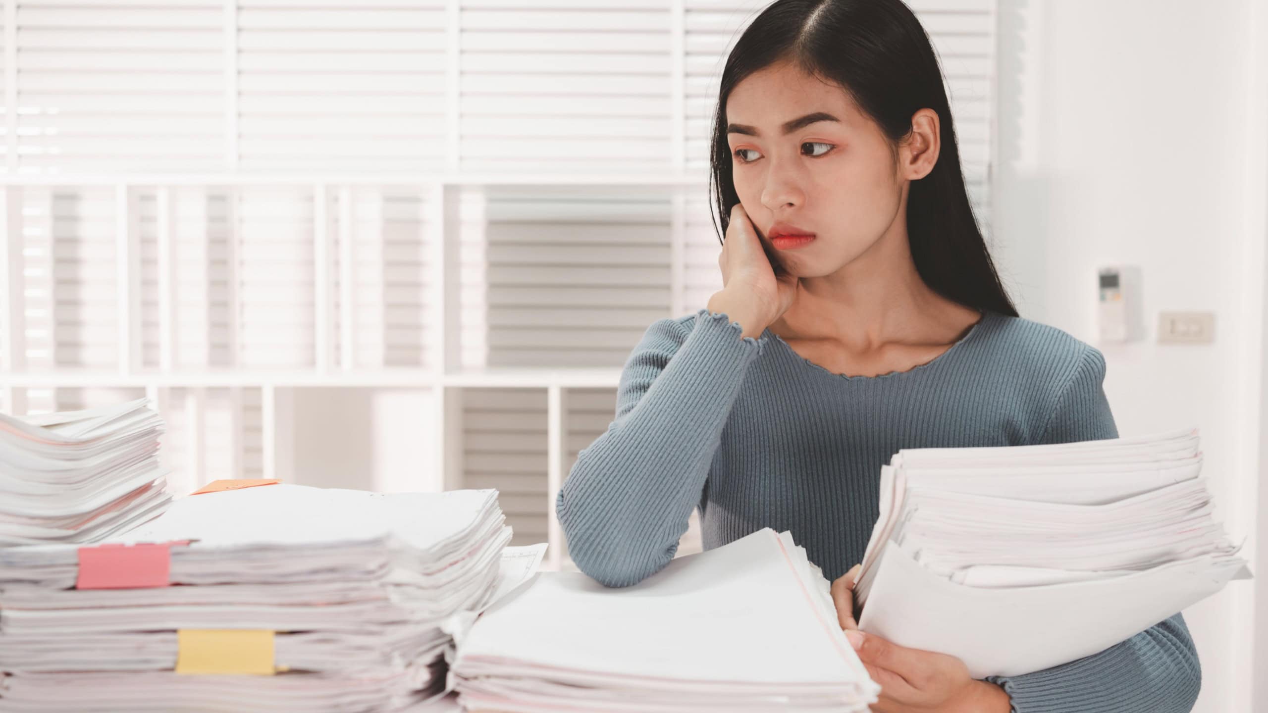 Female Employee woman hands working and searching in Stacks paper files.
