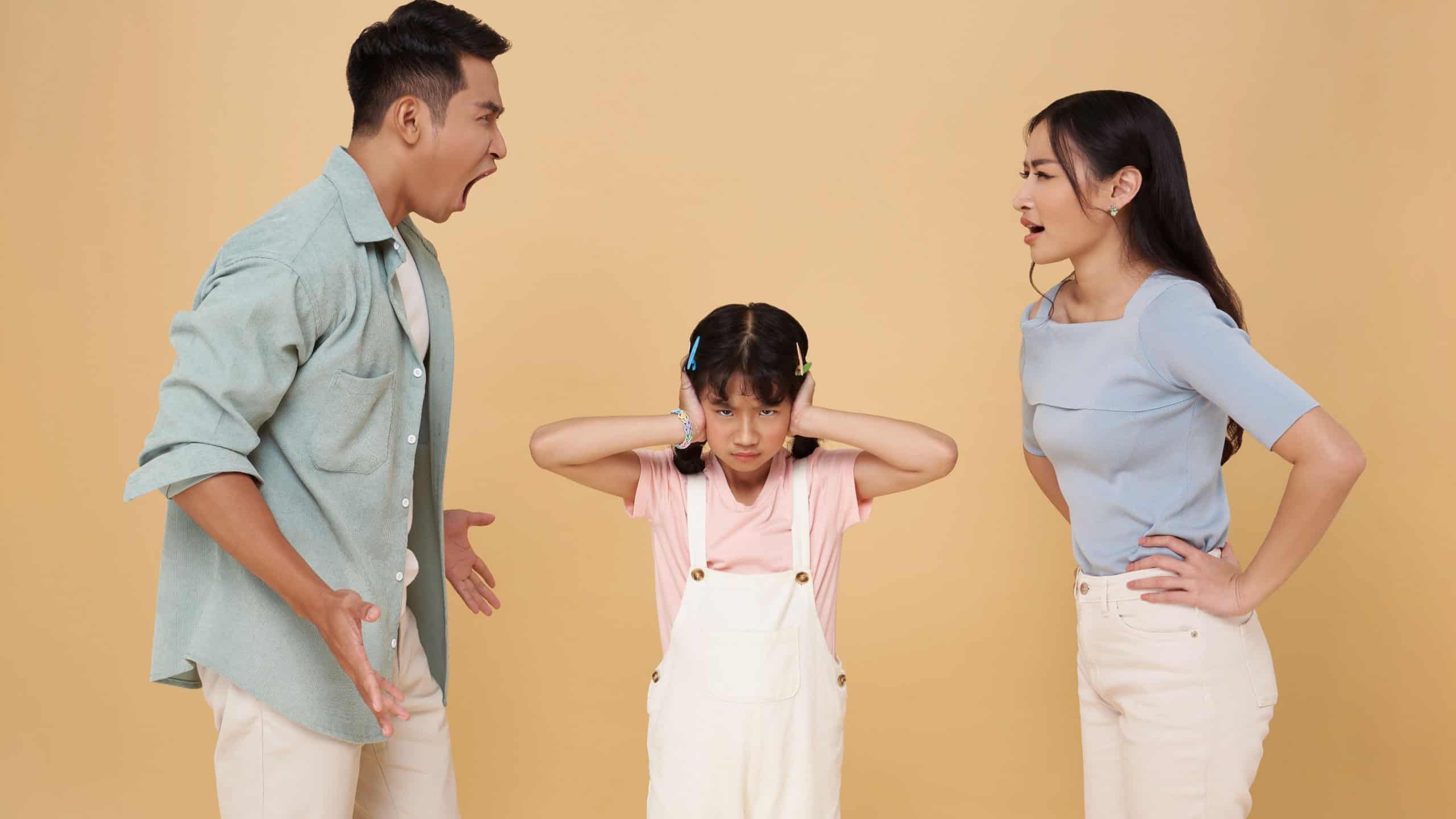 asian family quarrel in front of child isolated on nude color background. problems divorce violence concept