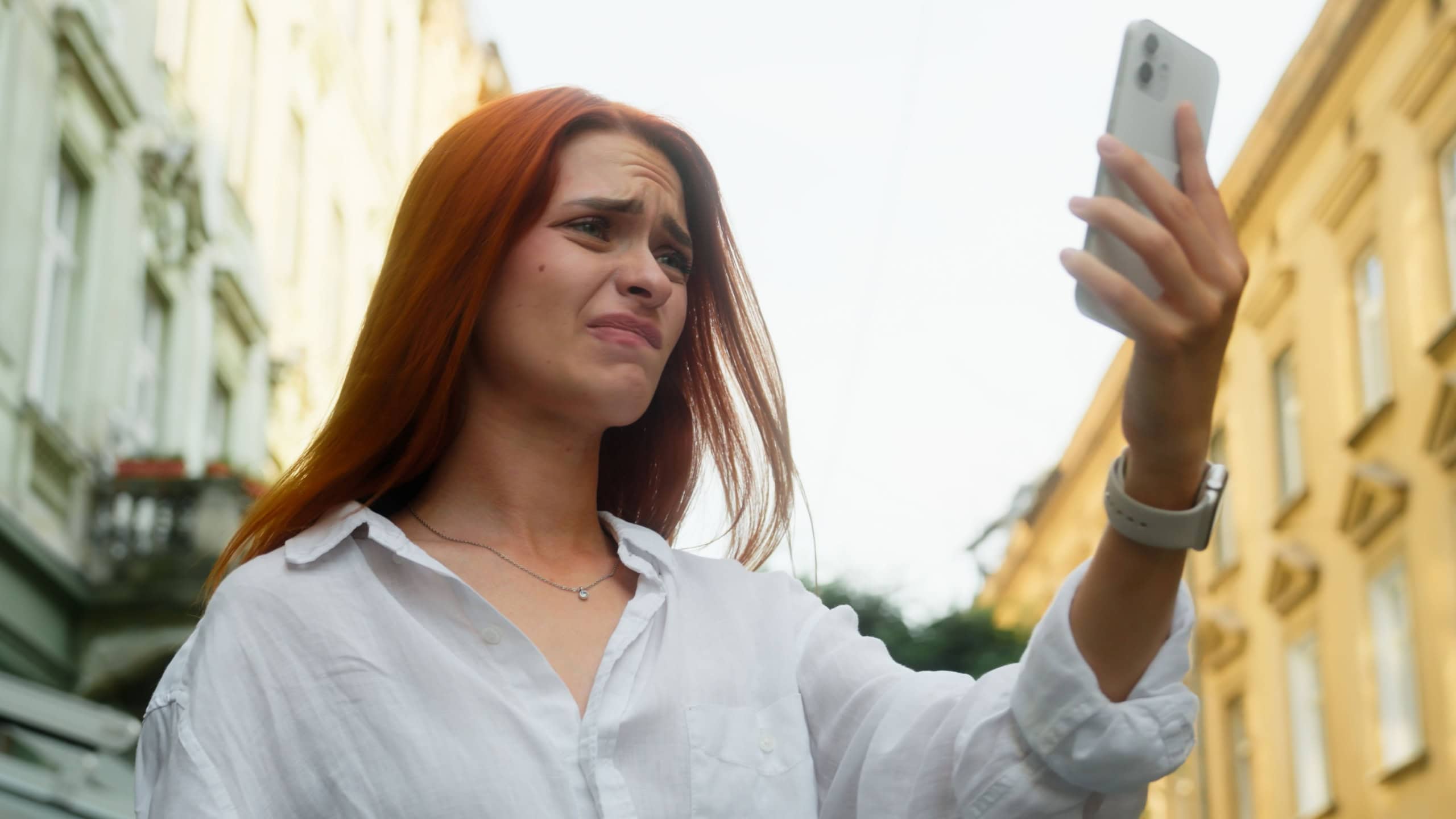 Upset confused Caucasian woman girl tourist smartphone user sad frustrated displeased businesswoman using mobile phone outdoors loss internet connection bad signal wi-fi roaming problem outside city