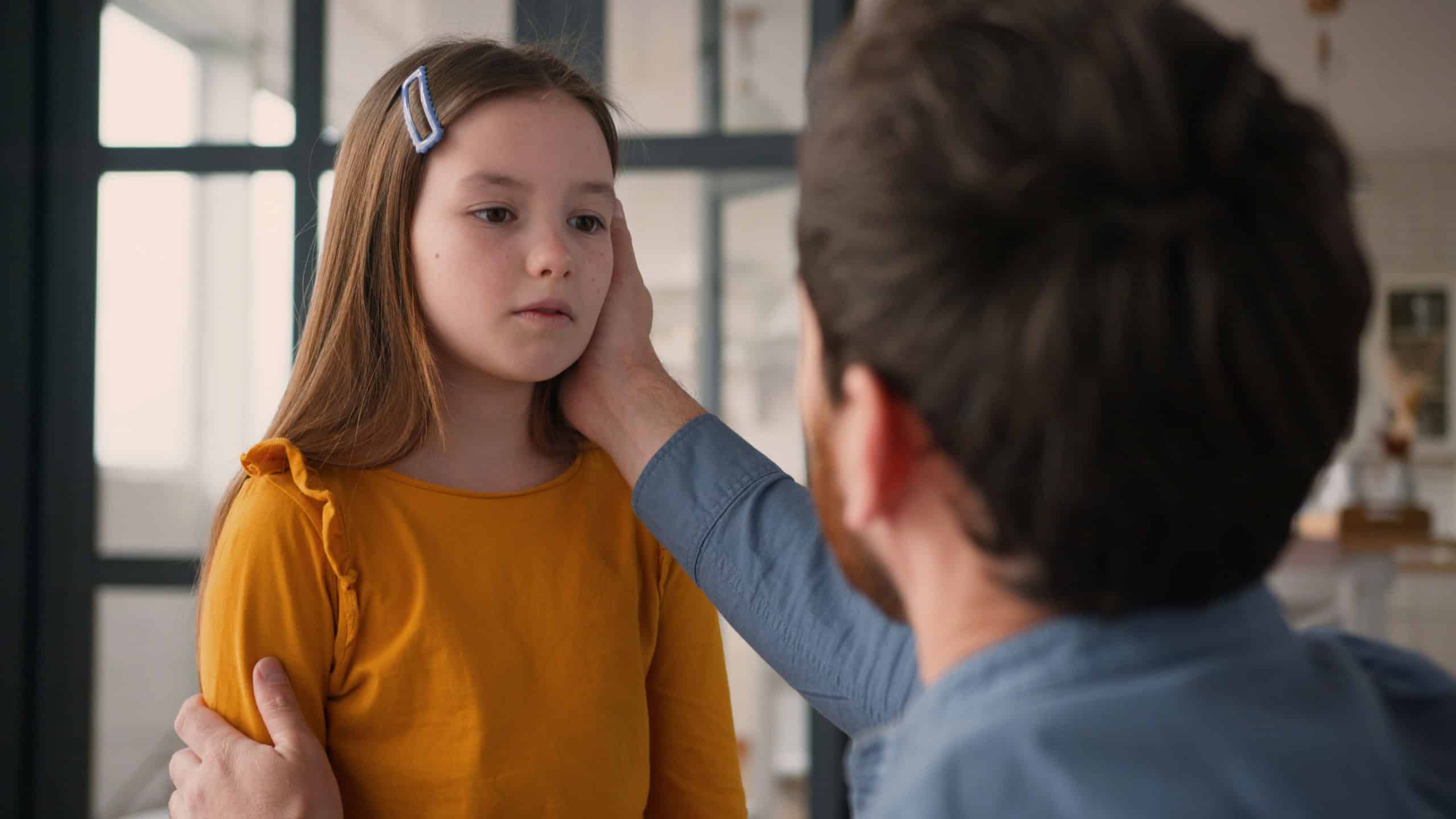 Caring Caucasian dad man guy male touching talk offended sad little child kid at home babysitter father parent apologize calming down mentoring upset daughter girl family argument disagreement problem