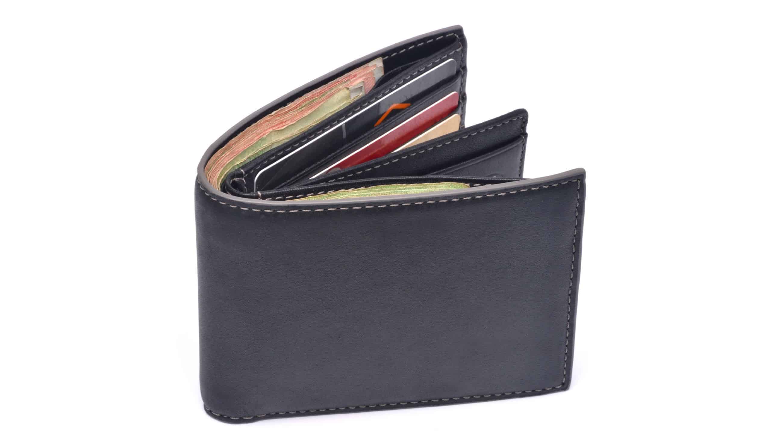 New Black leather wallet with banknotes and credit card isolated on white background.