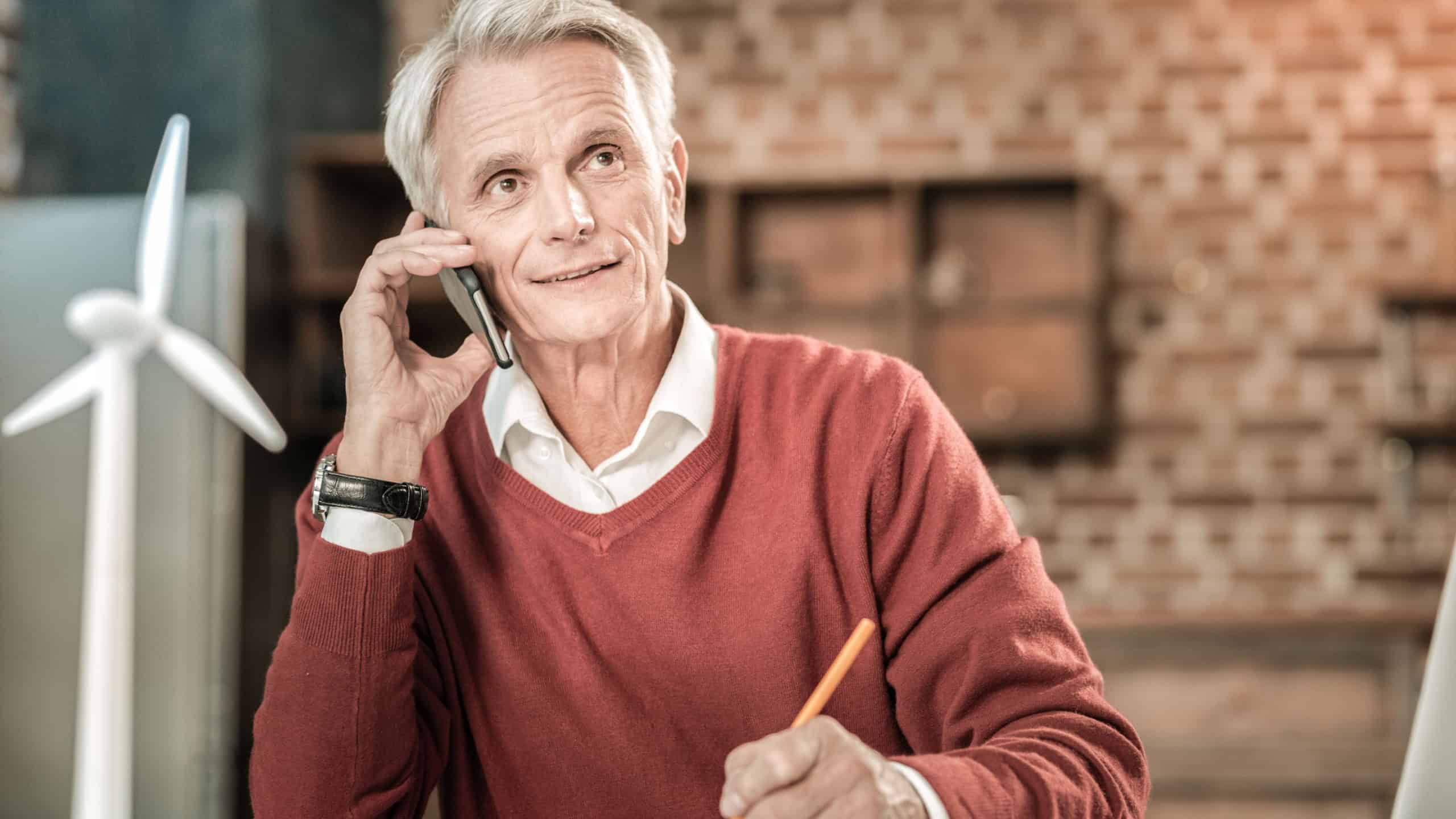 Older man talking on phone with a thoughtful expression.