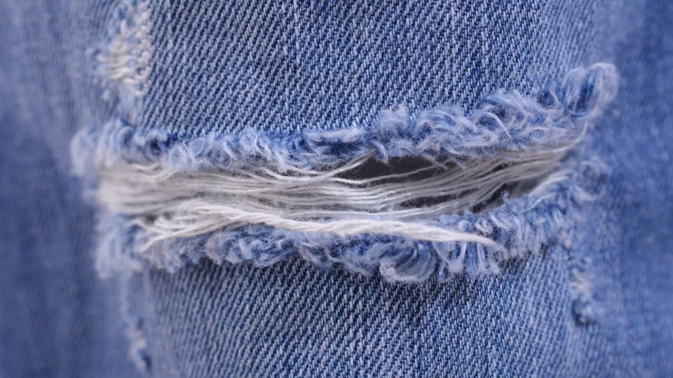 Ripped Destroyed Torn Blue jeans background.