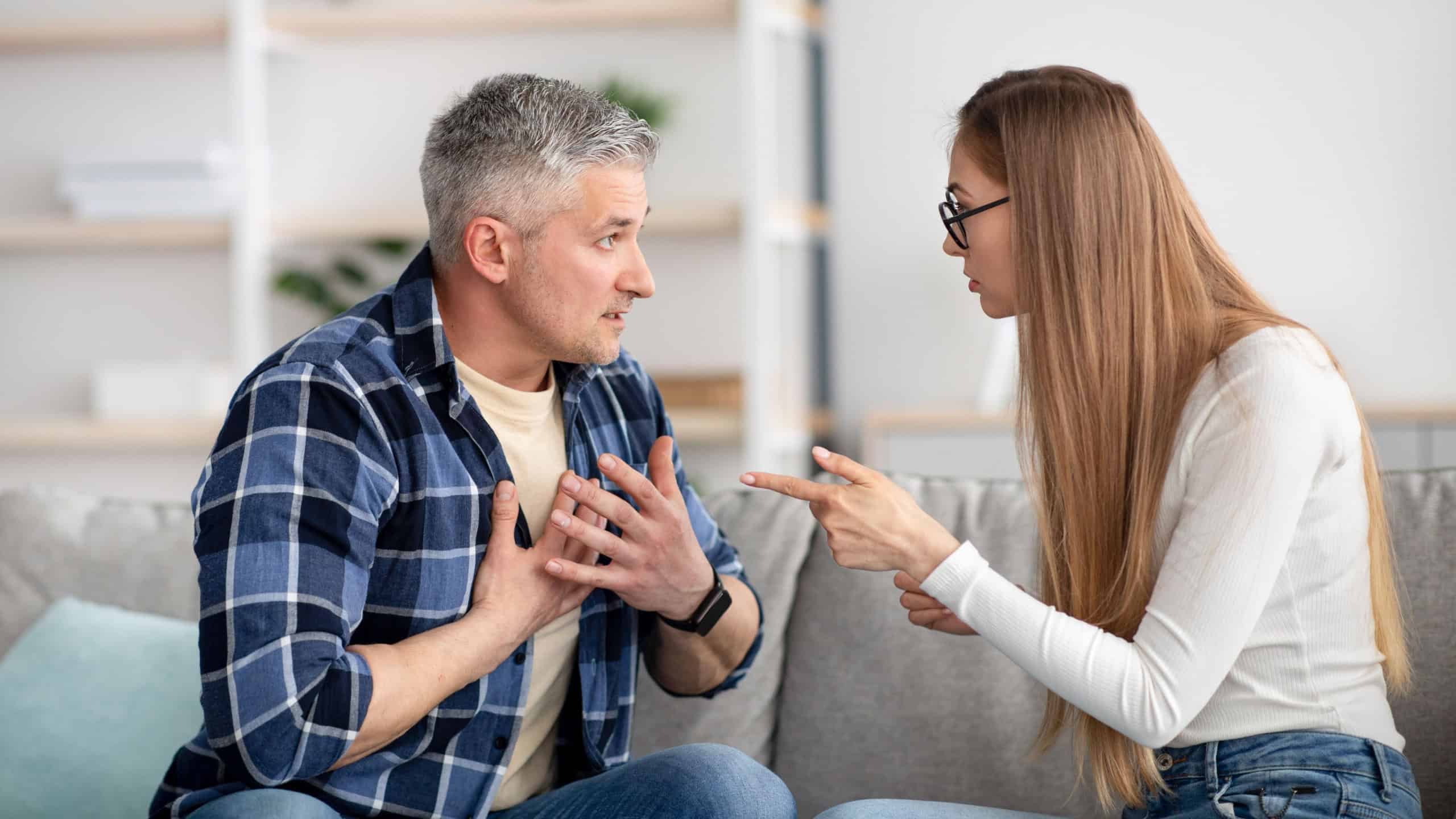 Irritated mature woman quarreling with her husband at home, being angry, experiencing family problems. Middle aged couple having conflict or disagreement. Marital crisis, breakup, divorce concept