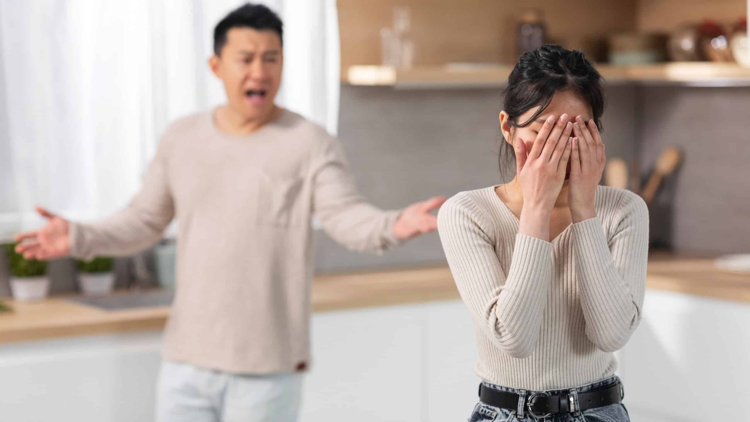 Emotional asian couple having fight at home, angry young asian man husband shouting at his crying wife, couple experiencing crisis in marriage, kitchen interior