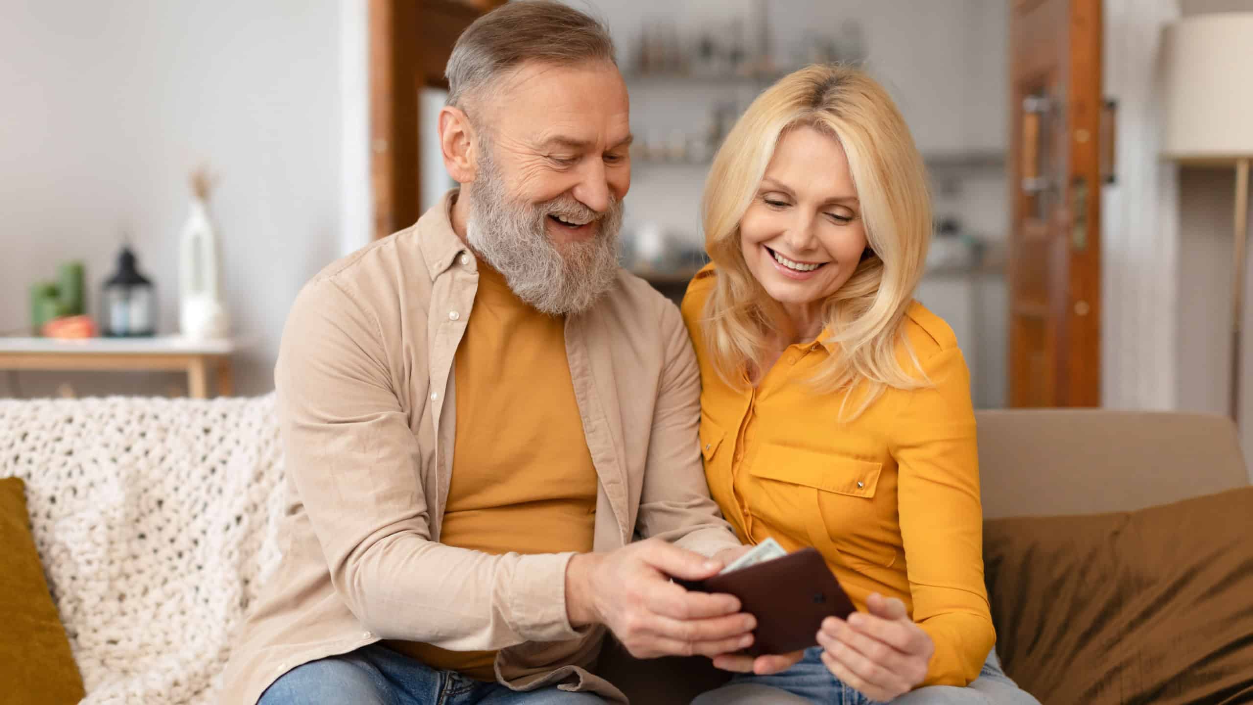 Joyful Rich Senior Couple Holding Wallet