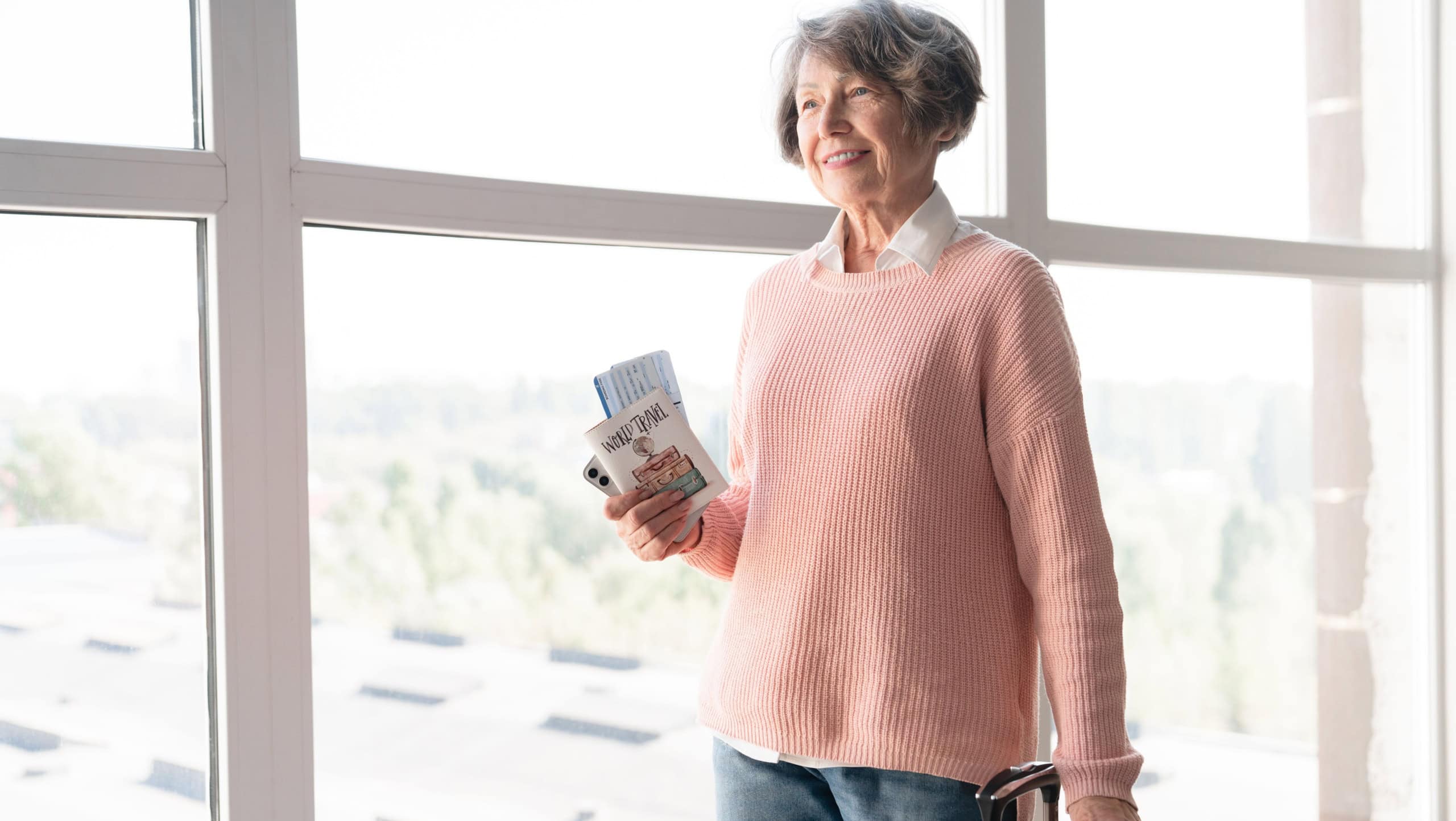 Cheerful european old elderly senior woman traveler with suitcase bags luggage baggage holding passport and airline tickets walking through airport train station waiting for flight, looking for gate