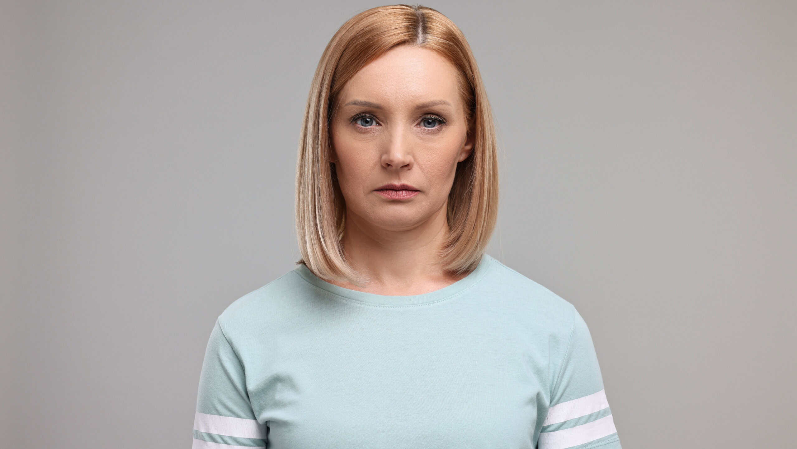 Portrait of sad woman on grey background