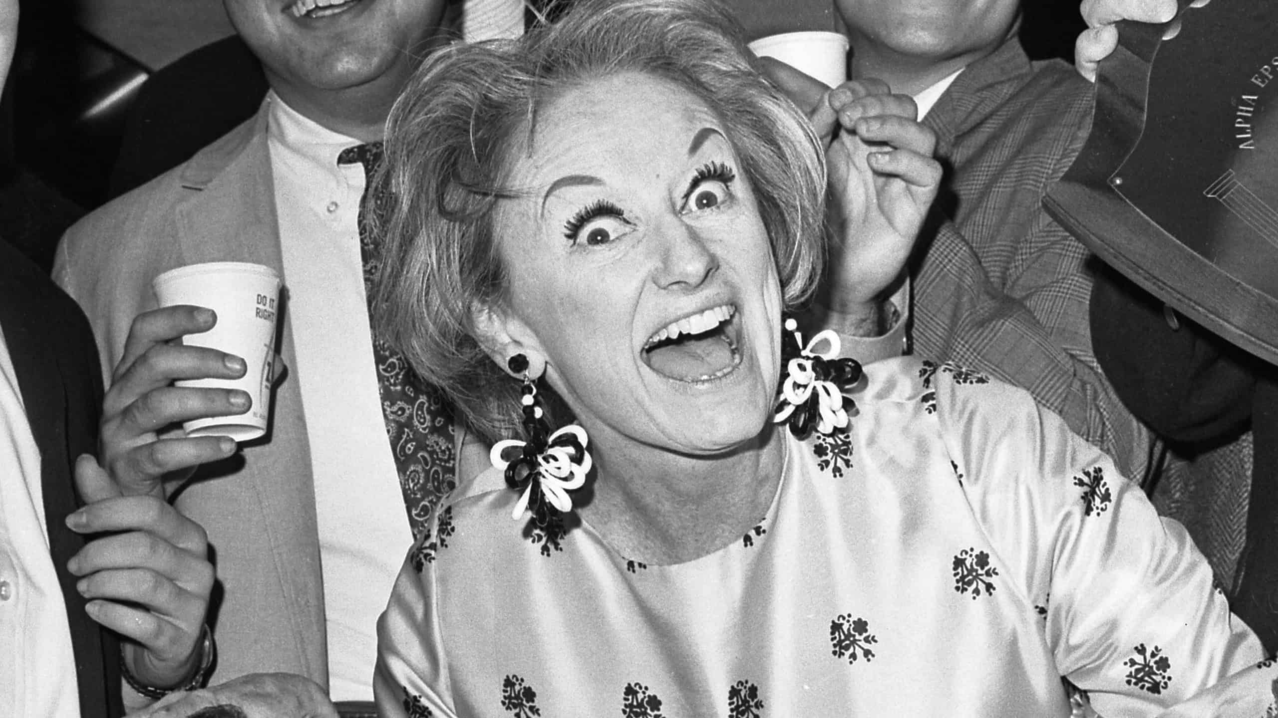 Comedienne Phyllis Diller is the center of attention as she becomes honorary house mother of Alpha Epsilon Pi Fraternity at UCLA. The president of the fraternity chapter, Lloyd Schwartz, right, prepares to present a plaque to the zany comedienne.