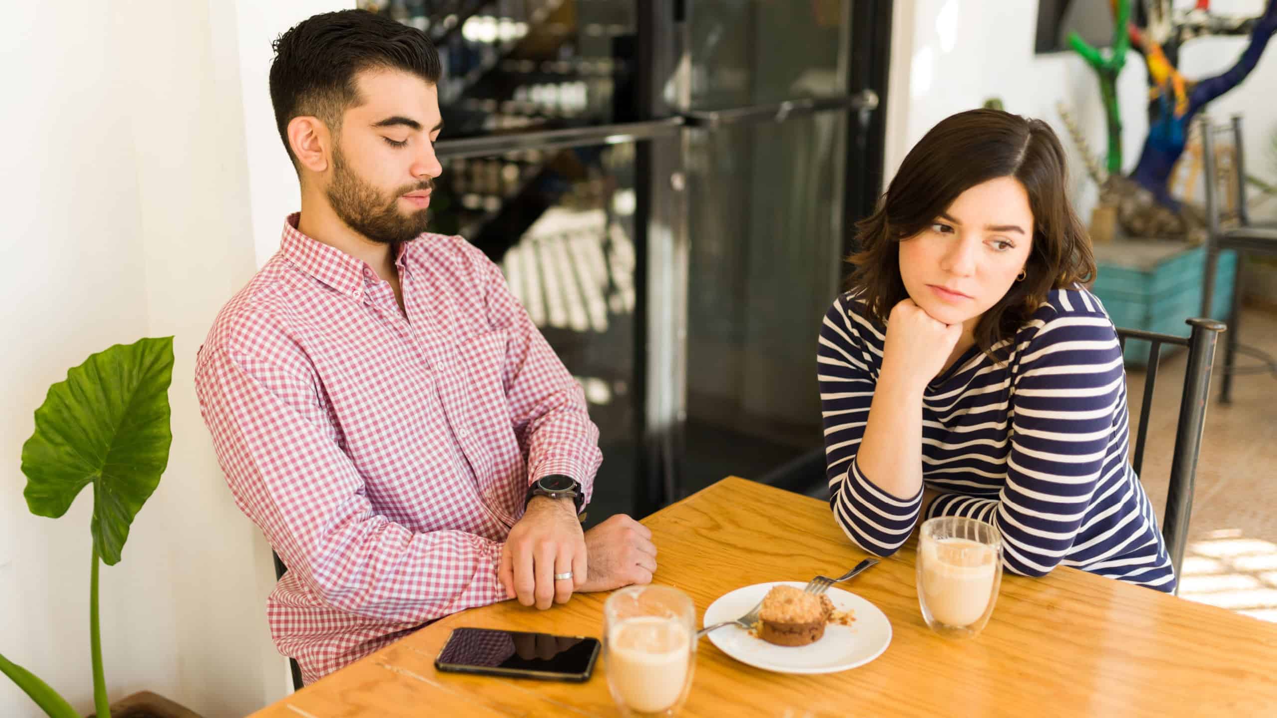 This is so boring. Young woman and man on a failed blind date feeling bored at the cafe