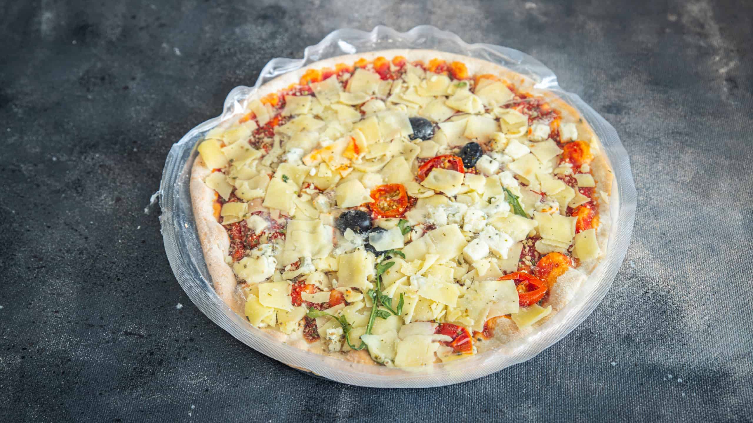 frozen pizza food packaging cling film cellophane quick defrost fresh healthy meal food snack diet on the table copy space food background rustic top view