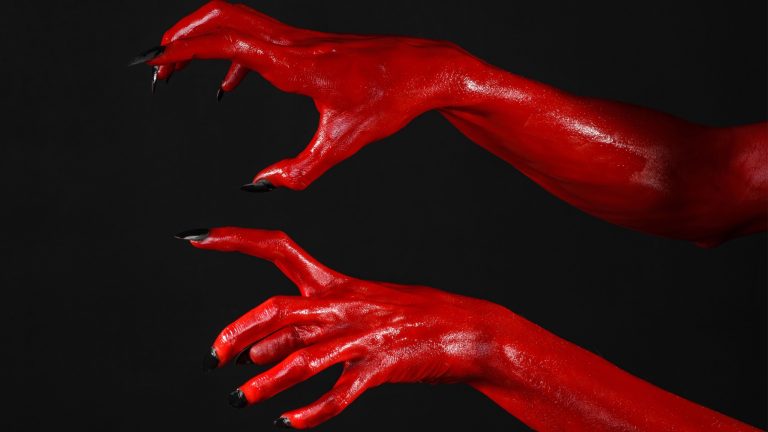 Red Devil's hands, red hands of Satan, Halloween theme, black background, isolated