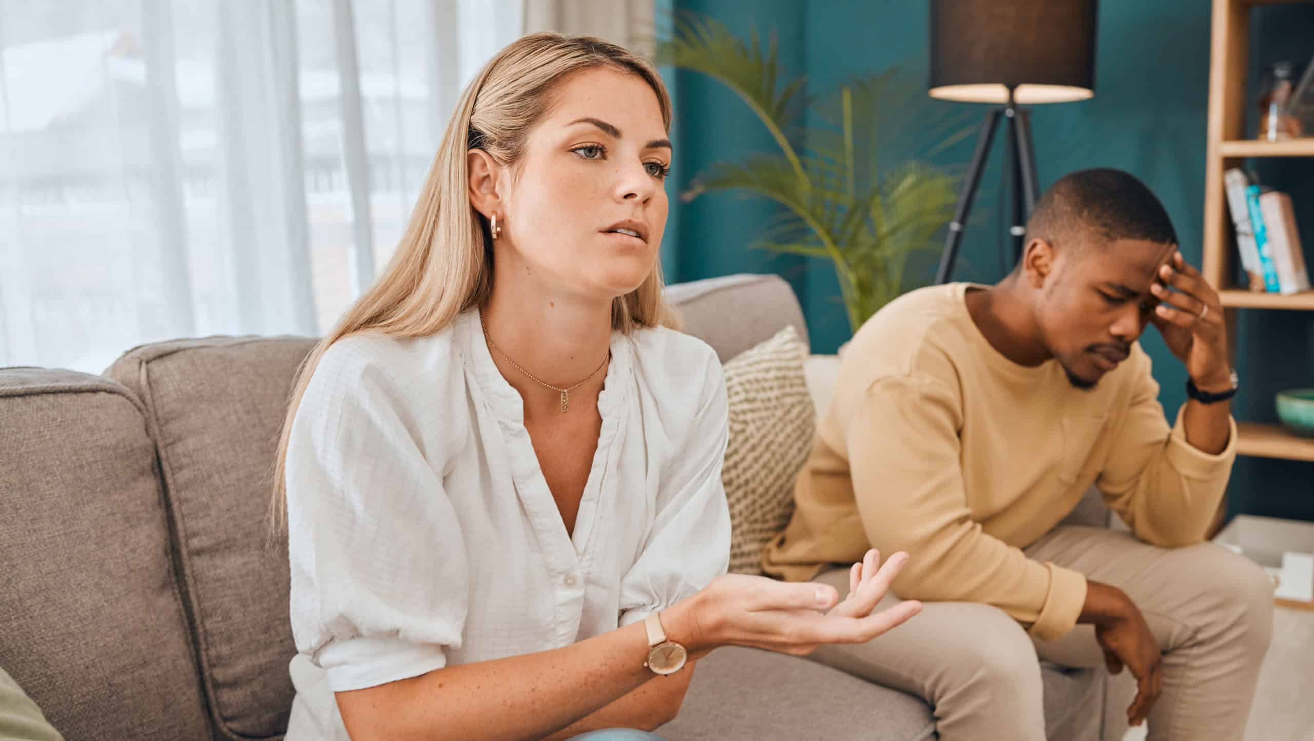 Interracial couple, counseling and frustrated woman and black man on therapy sofa talking. Tired, relationship stress and marriage problem of people on couch feeling anxiety from divorce conversation
