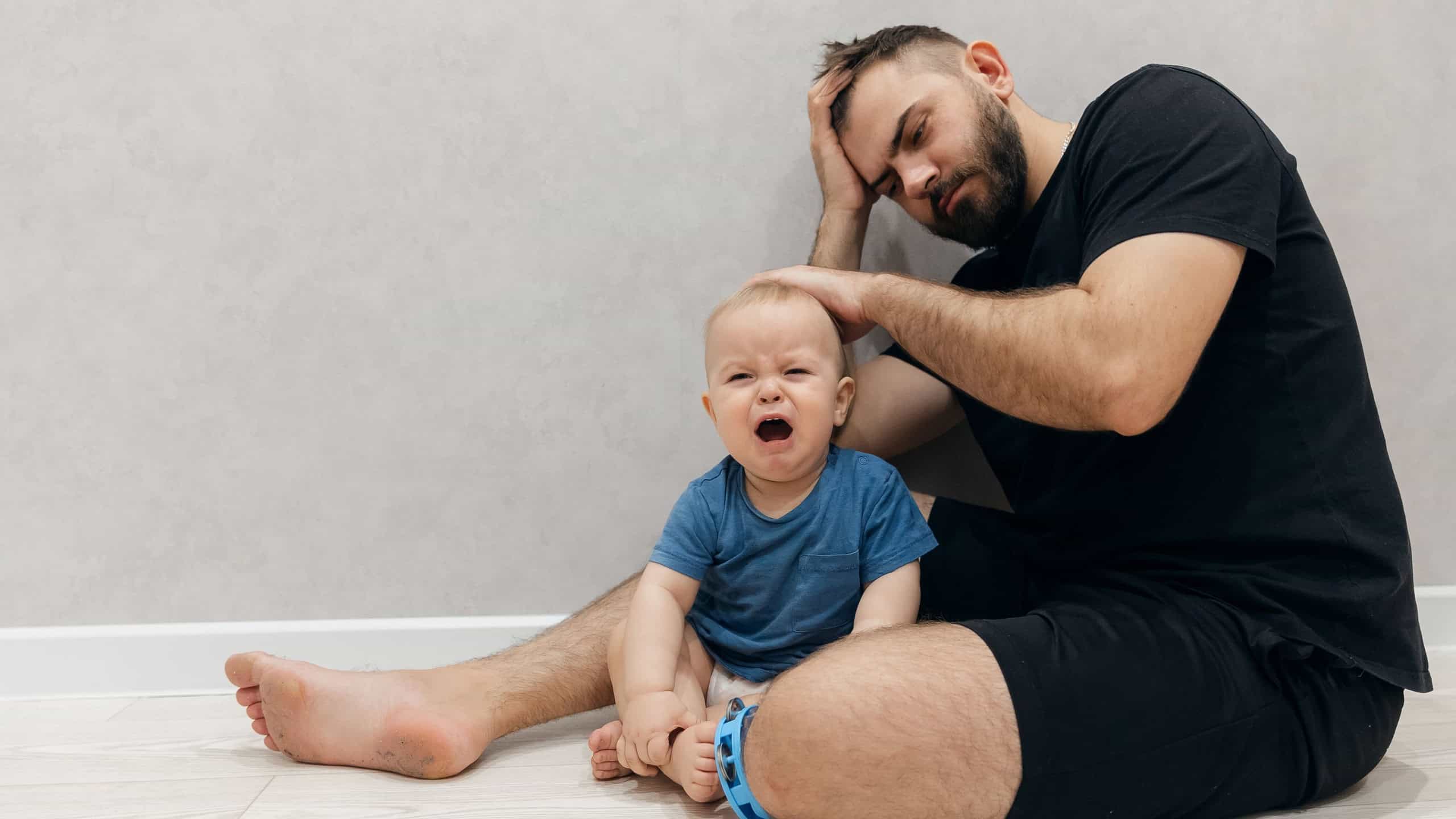 Baby cry, father confused and calms of boy. Dad man experiences difficulty in raising and caring for child in living room. Concept lifestyle parenting fatherhood moment.