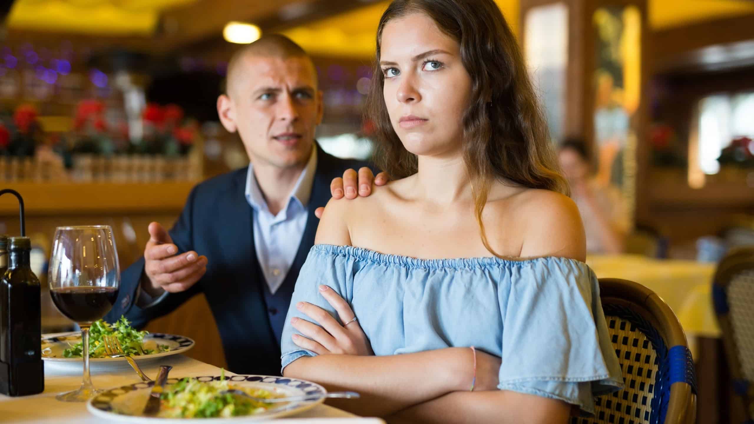 Disgruntled man and woman quarreling and emotionally gesturing, having bad date in restaurant