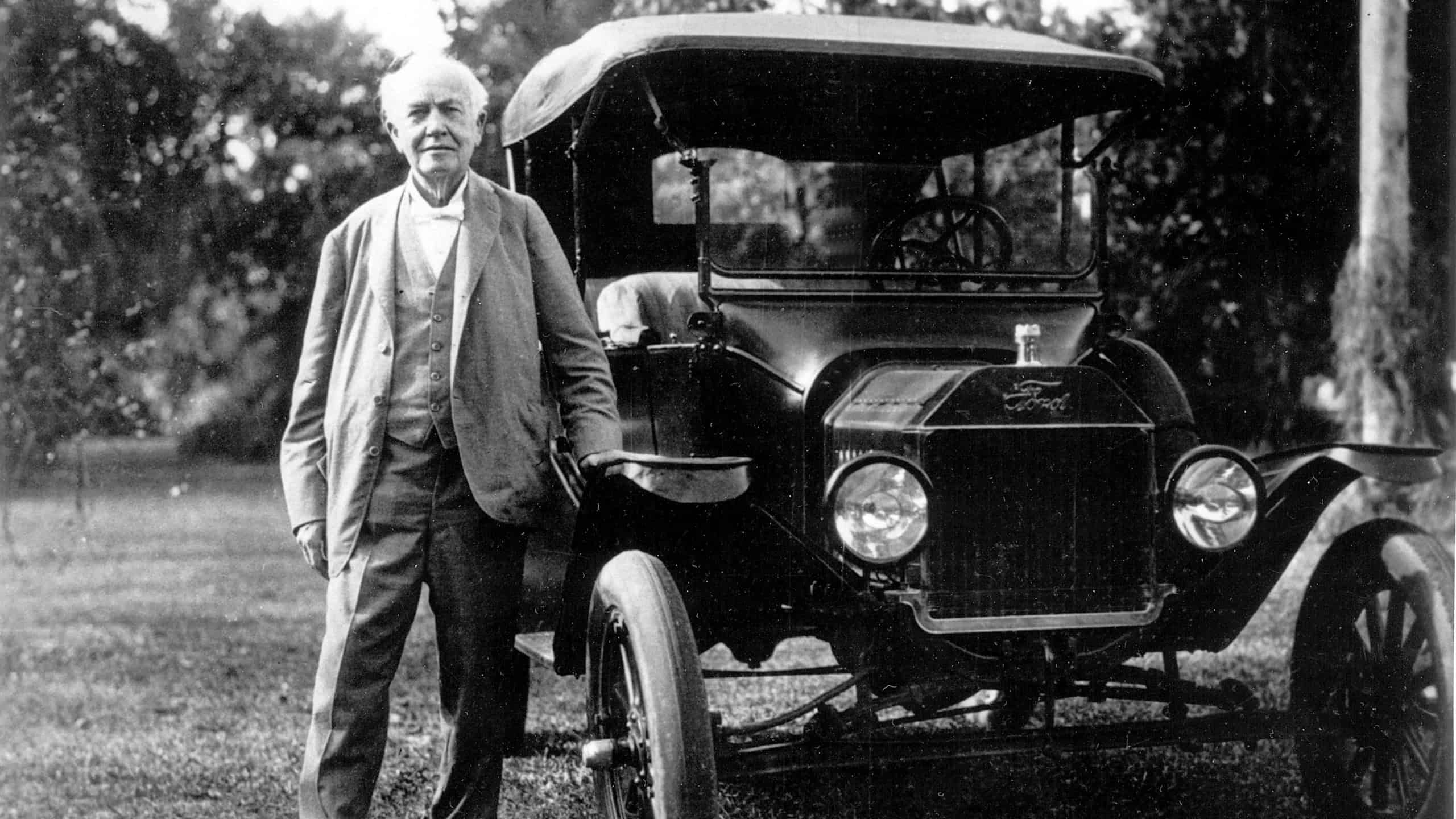 Henry Ford standing by a car.