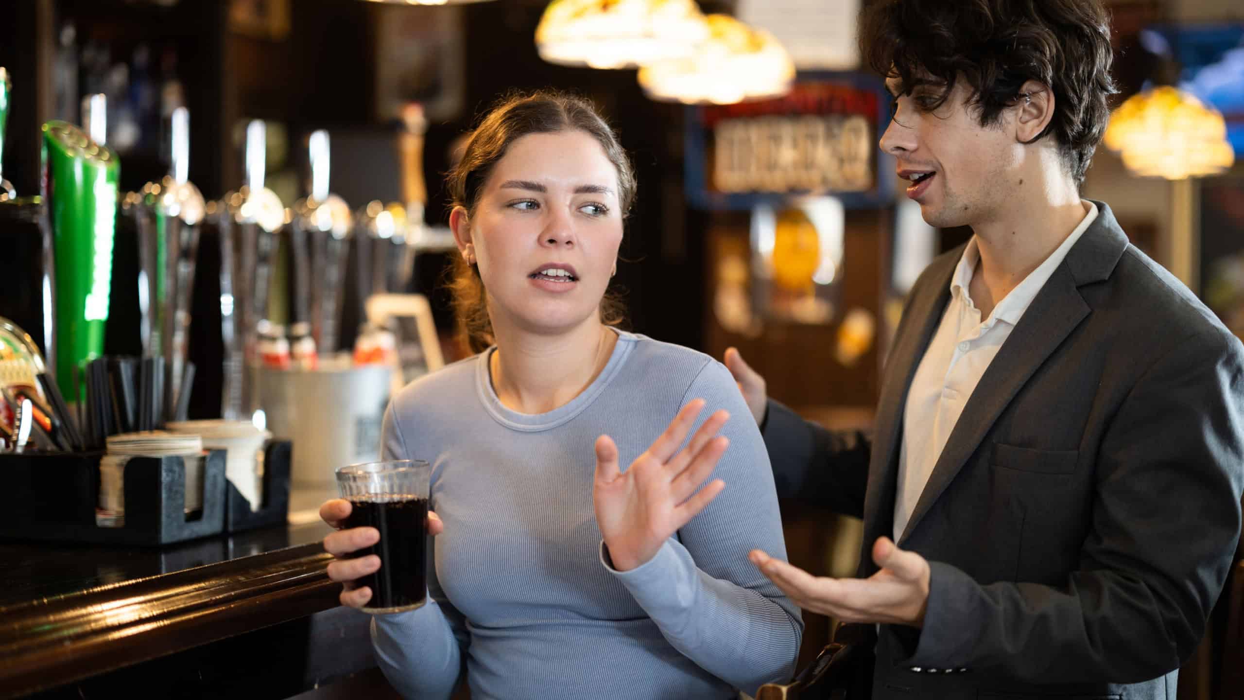 Woman is annoyed by a flirting man. Man meets a young woman in a bar and gets rejected