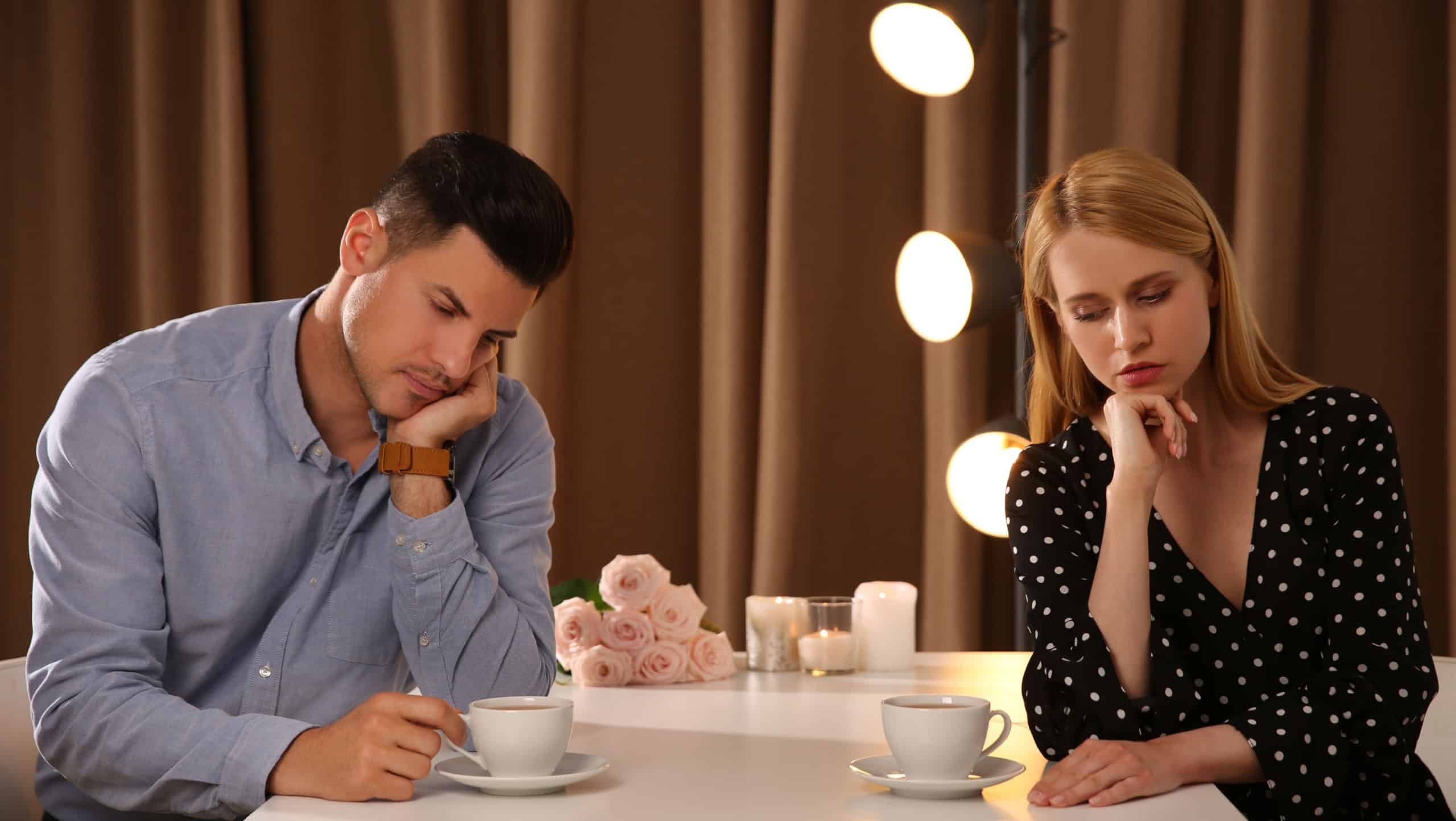 Displeased man and young woman in restaurant. Failed first date