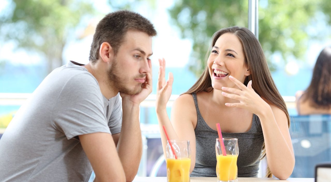 Bored man listening her friend talking in a coffee shop or hotel on the beach