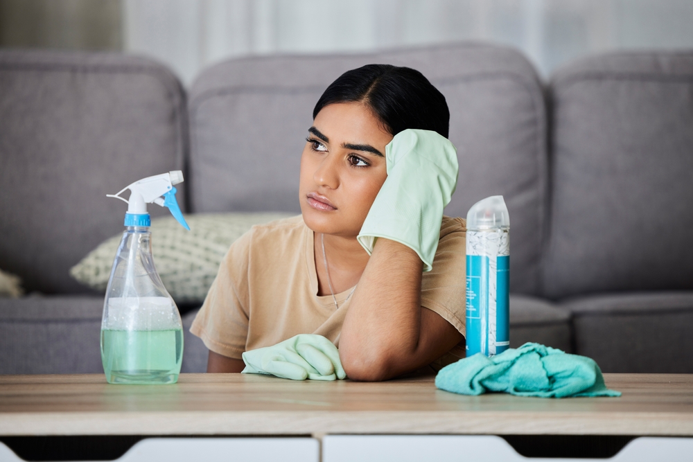 House, cleaning and bored woman thinking, tired and annoyed with household task, sad and frustrated. Lazy, cleaner and Indian girl contemplating, daydream and distracted from bacteria or dust cleanup