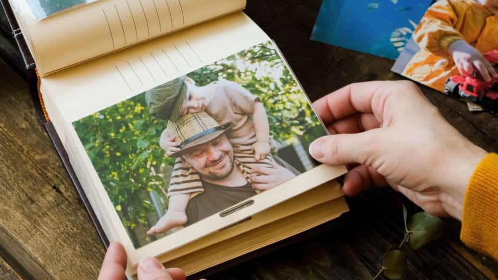 Female hands holds printed photo for family photo album.