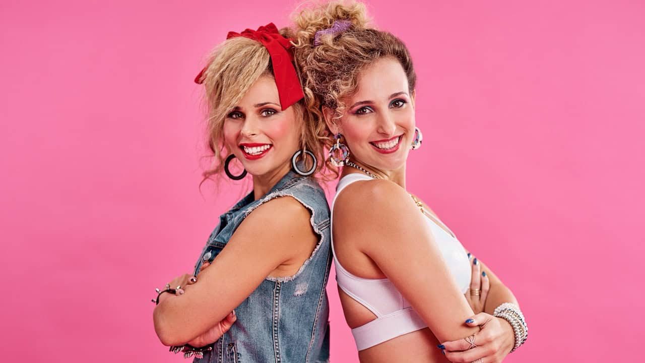 Friends, 80s fashion and portrait of happy women in studio together with smile, vintage theme and pink background. Friendship, fun and woman with friend, retro clothes and hairstyle with jewellery.