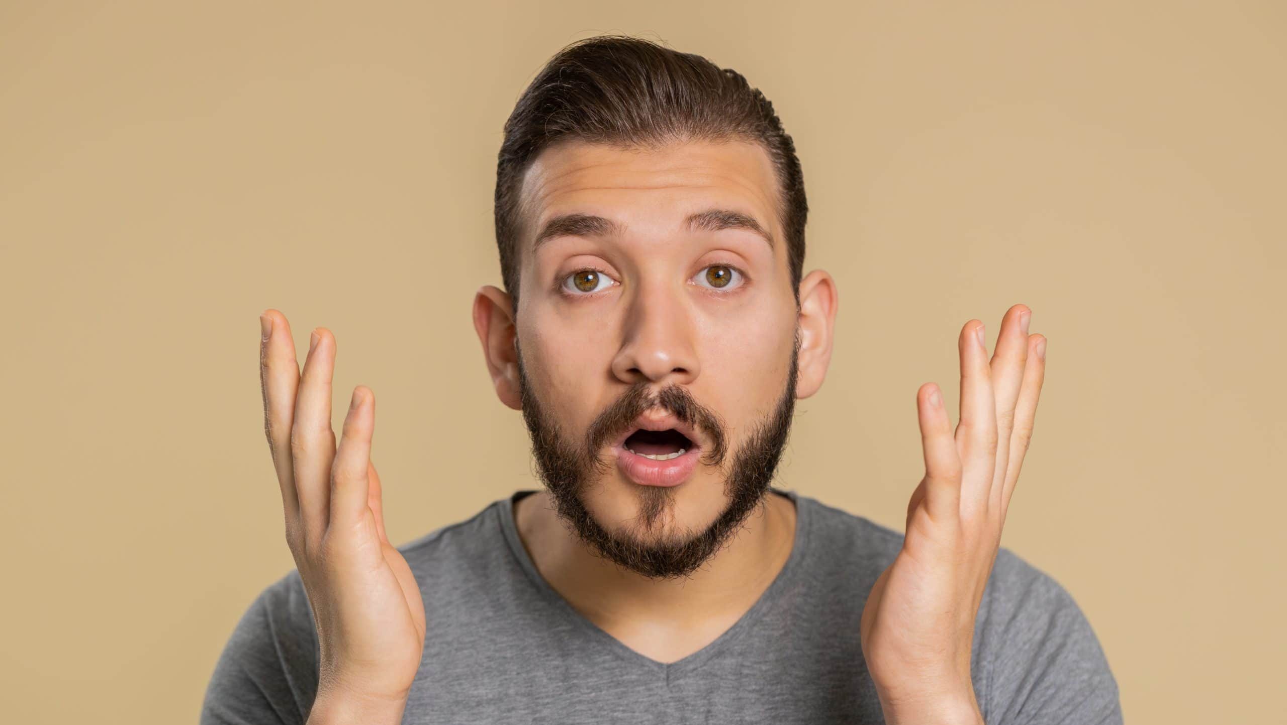 Oh my God, Wow. Excited amazed winner man surprise looking at camera with big eyes, shocked by sudden victory. Sincere confused shocked handsome lebanese guy isolated alone on beige studio background