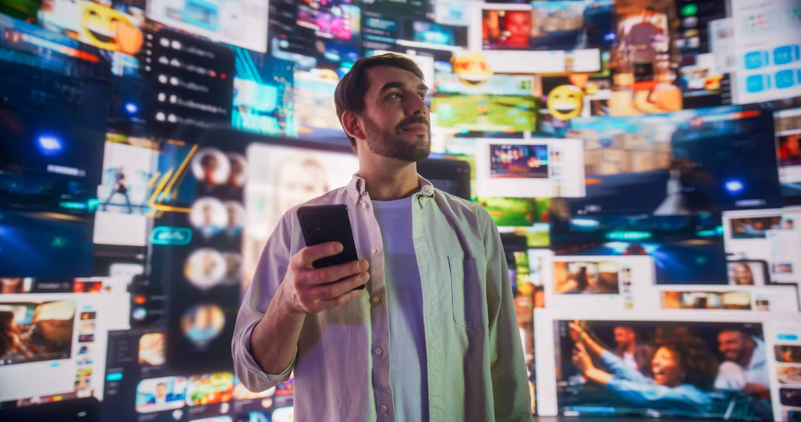 Portrait of Caucasian Man Using Smartphone in Metaverse With Animated Stream Of Interfaces With Social Media, e-Commerce Shopping, Internet Influencers And Games. Visualization Of Web Network.