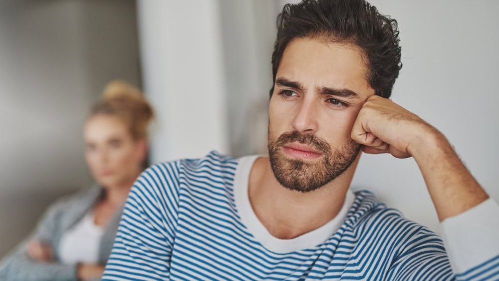 Man, silent and couple conflict in home, disagreement and betrayal or abuse in toxic marriage. People, ignoring and relationship mistake or fail in living room, divorce and stubborn fighting on sofa