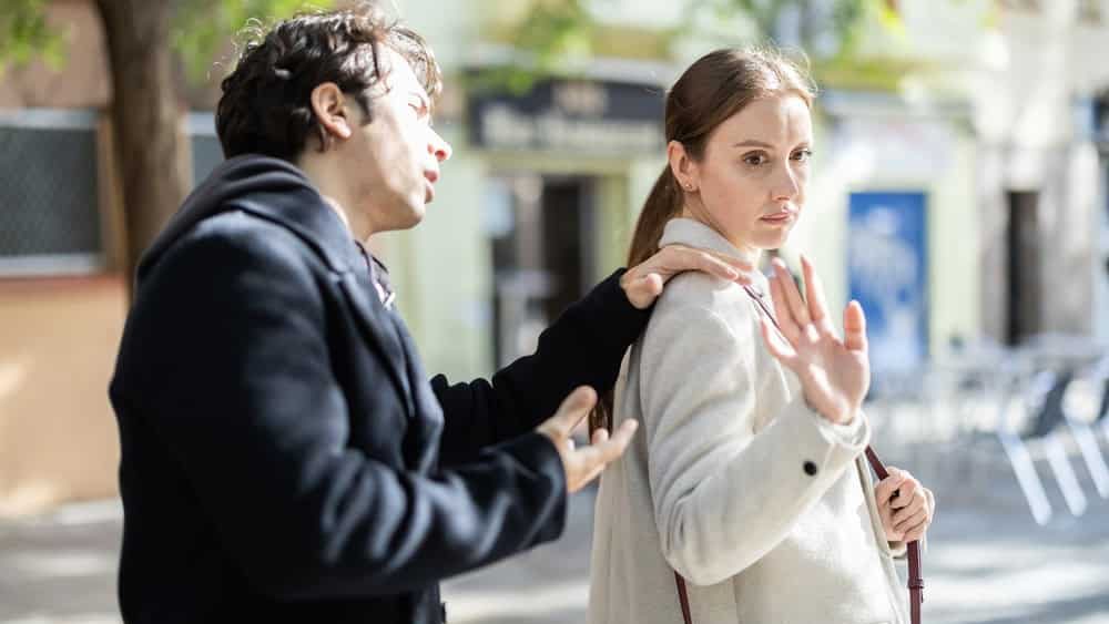 Irritated displeased woman stopping stranger guy flirting with her on spring city street