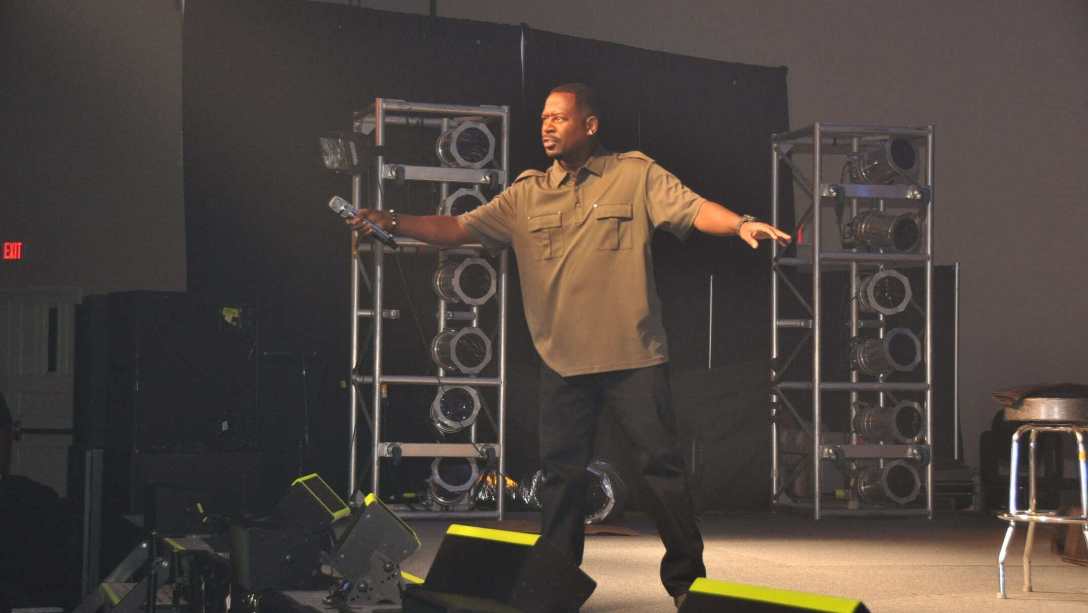 Martin Lawrence points his microphone to the audience to make some noise as he performs during the Tour for the Troops show presented by the Air Force Reserve at the Centennial Banquet and Conference Center at East Fort Bliss, Aug. 10.