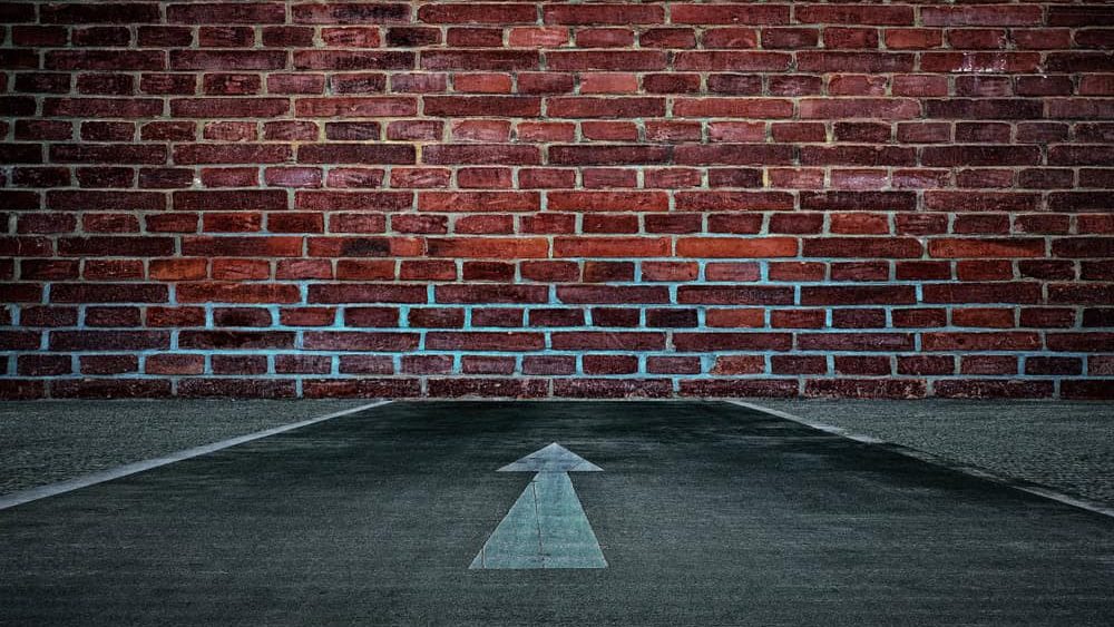 White Arrow on the Road Straight to the Old Brick Wall Background, Suitable for Business Dead End Concept.