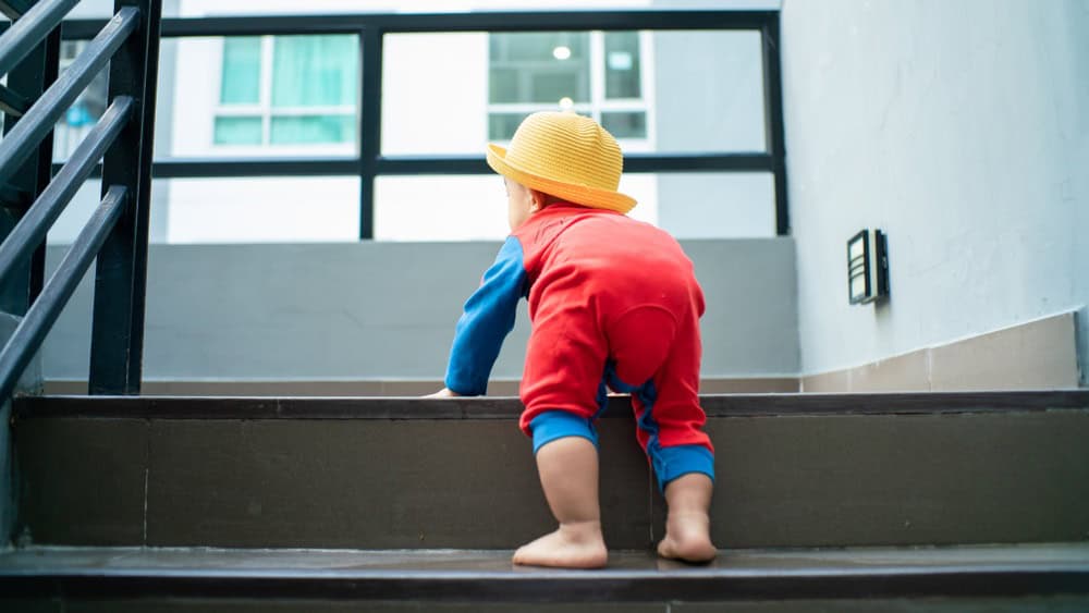 Funny baby boy crawling climbs up stair, Baby development