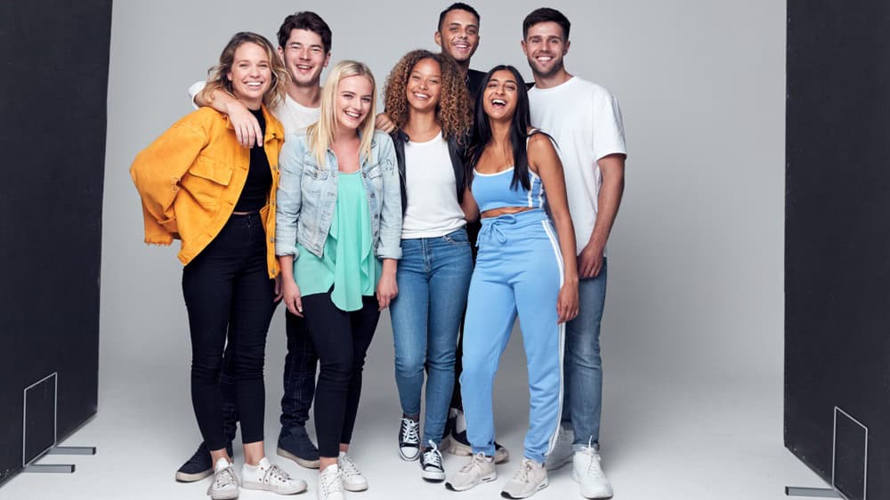 Group Studio Photo Shoot Of Young Multi-Cultural Friends Smiling And Laughing At Camera
