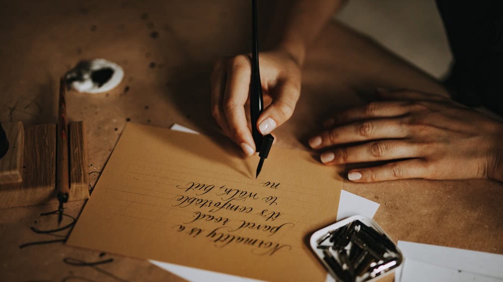 Someone using fountain pen and writing words, sending letter.