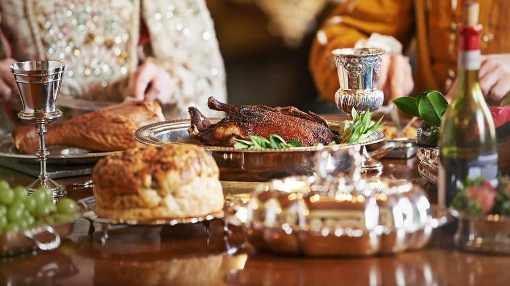 The nobility feasts while the people hunger. Cropped shot of a noble couple eating together in the palace dining room.