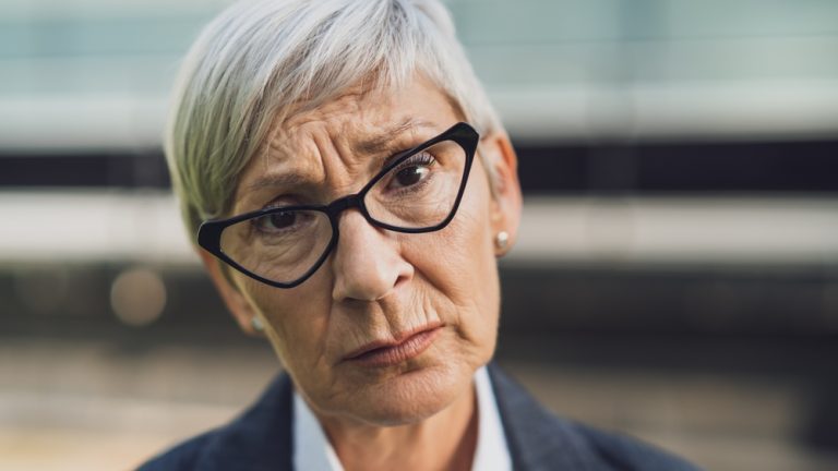 Close up portrait of senior businesswoman who is sad and worried.