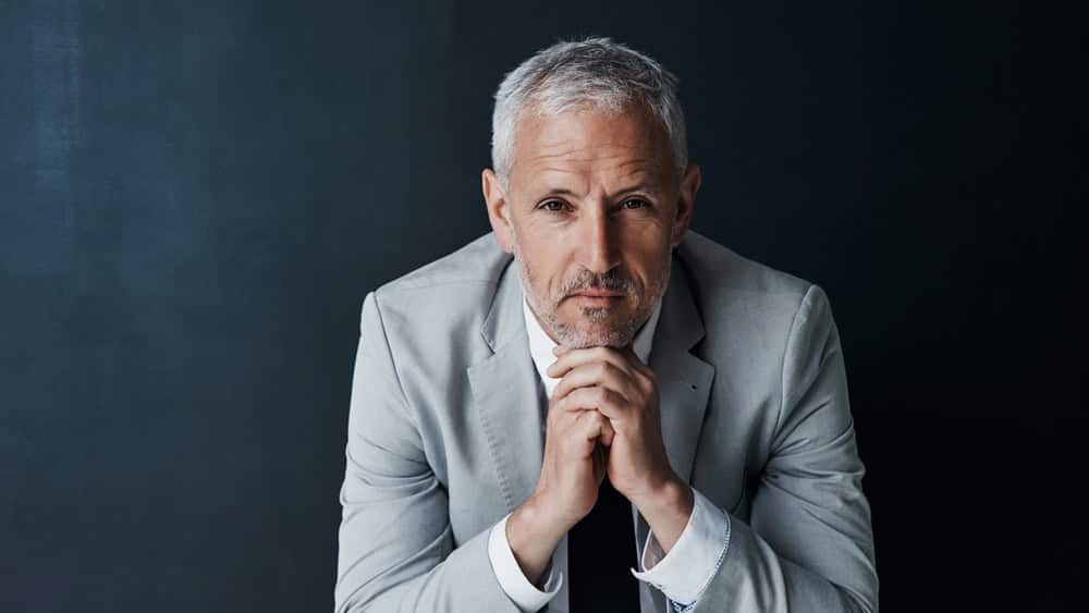 Serious portrait of senior attorney sitting with confidence, mockup space and dark background in studio. Pride, professional career ceo and executive lawyer man, mature businessman or law firm boss.