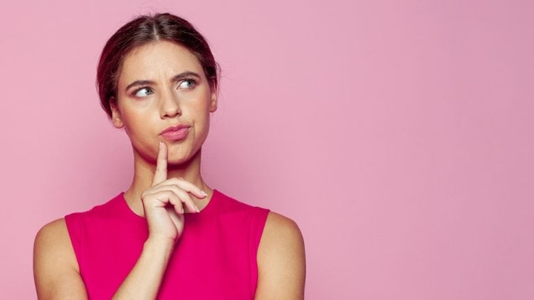 Attractive young woman thinking on pink background. Idea and brainstorming concept