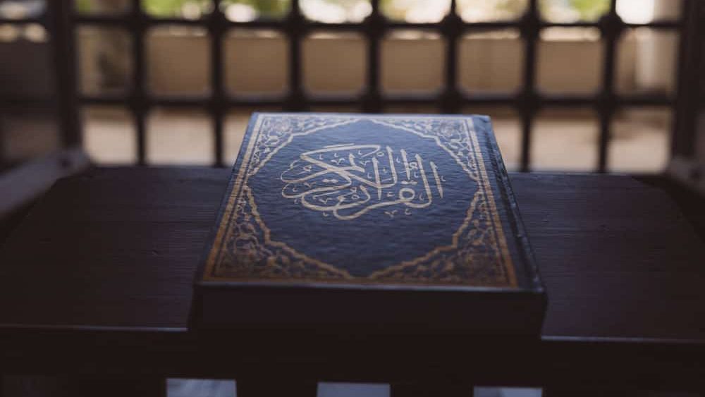 Islamic background photo. The Holy Quran on the book stand in a mosque. Ramadan kareem or eid mubarak or laylat al-qadr or kadir gecesi background. The Noble Quran text on the image.