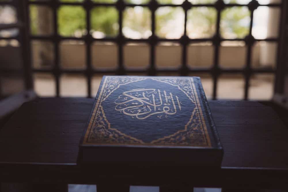 Islamic background photo. The Holy Quran on the book stand in a mosque. Ramadan kareem or eid mubarak or laylat al-qadr or kadir gecesi background. The Noble Quran text on the image.
