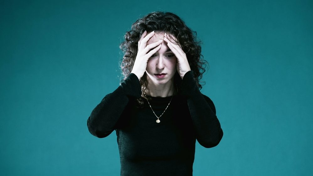 Tormented Woman with Face in Hands, Overwhelmed by Regret and Past Memories covers face in anguish