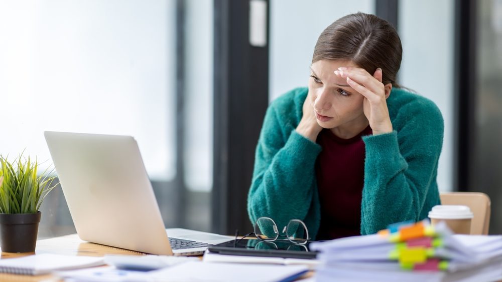 Portrait of sad depressed tired woman bored while working in the office workplace.