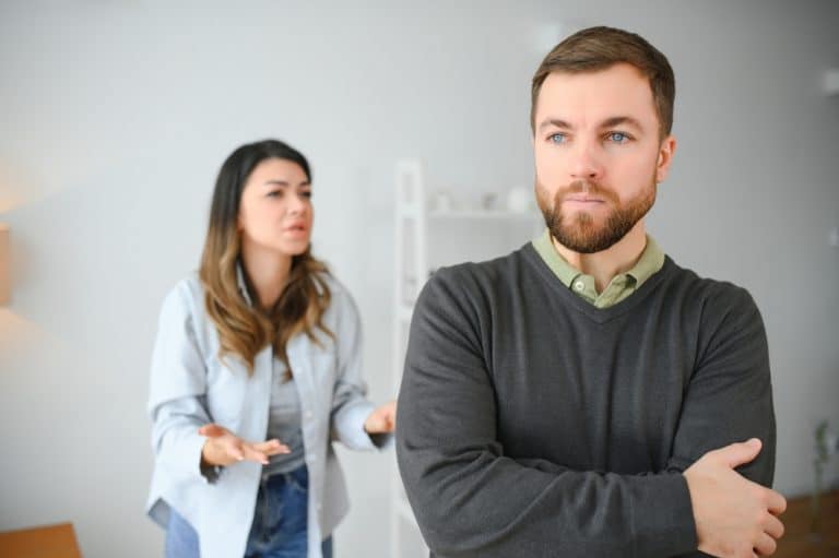 Family quarrel, man and woman sitting on sofa at home. angry woman yells at her husband.