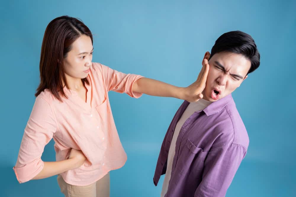 Photo of young Asian couple on blue background