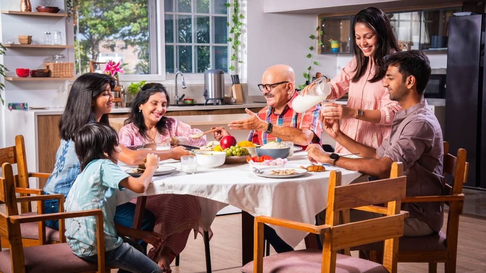 Happy multi-generation asian Indian family enjoying lunch together at home.