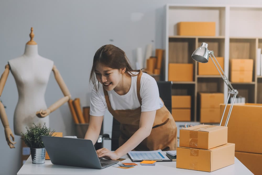 Asian SME business women use laptop computer checking customer order online shipping boxes at home. Starting Small business entrepreneur SME freelance. Online business, Work at home concept.
